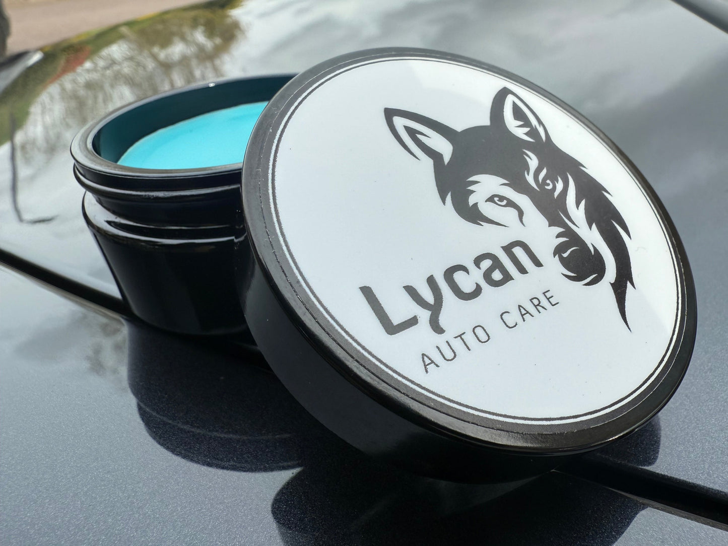 Lycan Auto Care Wax in a black jar with a blue lid for superior car protection and shine