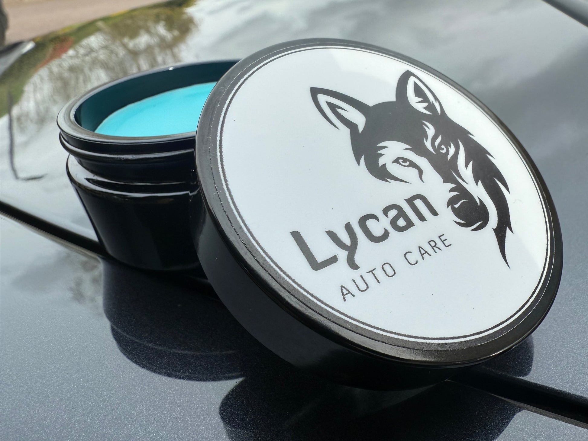 Lycan Auto Care Wax in a black jar with a blue lid for superior car protection and shine